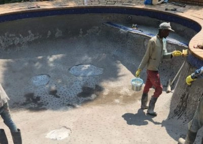 Guys working inside a custom concrete pool project.