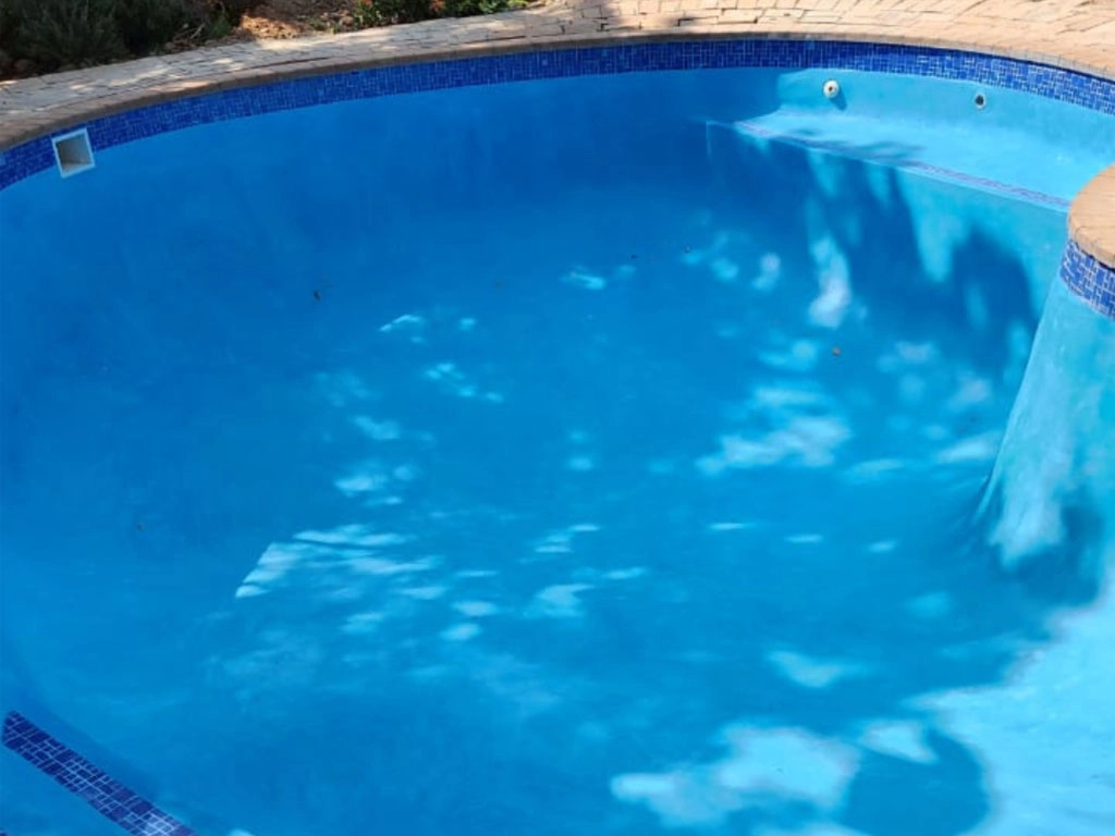 Finished custom concrete pool project with blue interior.