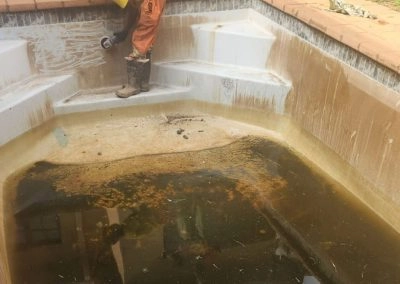 Cleaning a dirty concrete pool.