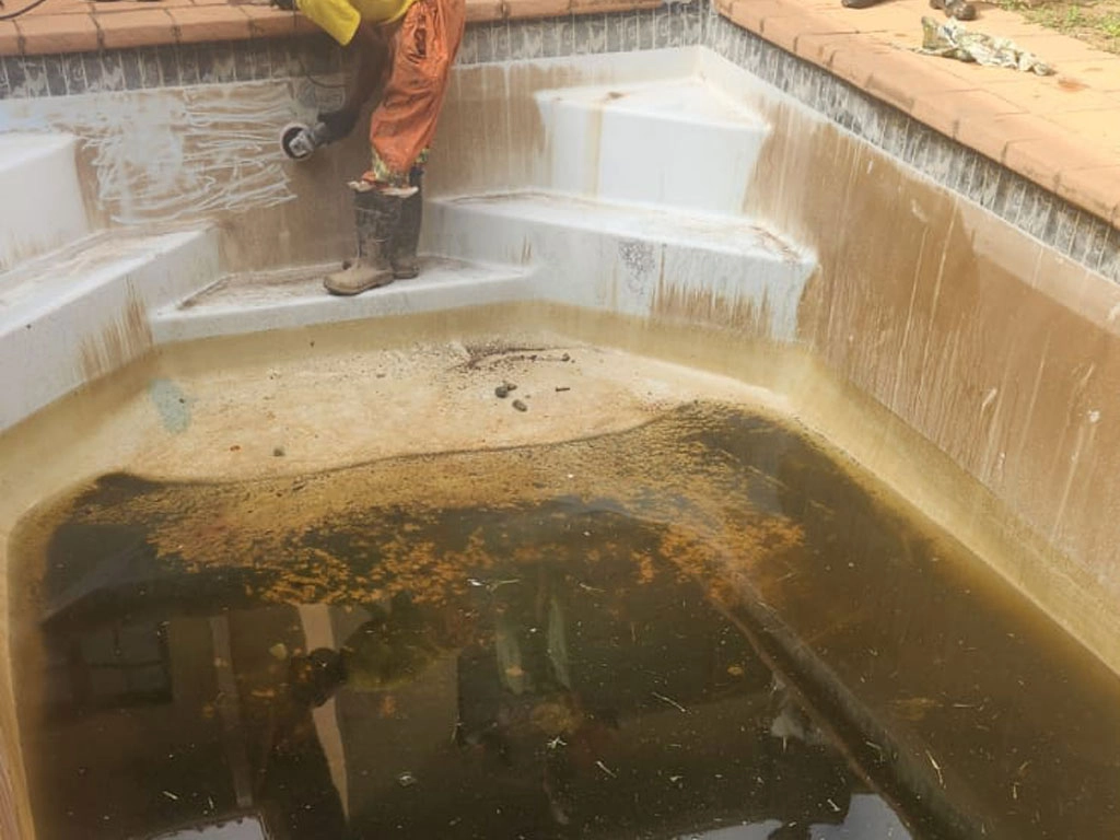 Cleaning a dirty concrete pool.