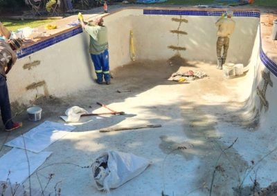 Guys busy working in the concrete pool, fixing cracks.